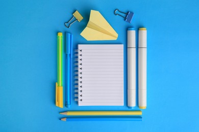 Photo of Paper plane and different school stationery on light blue background, flat lay with space for text. Back to school