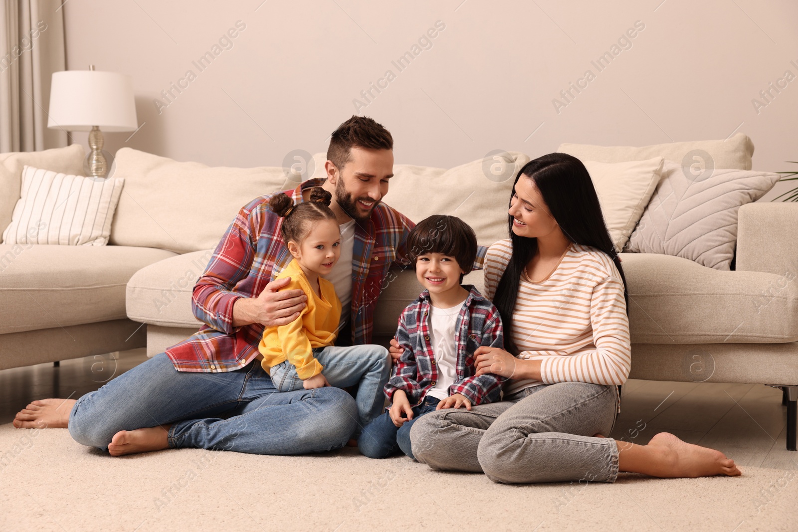 Photo of Happy family spending time together in living room