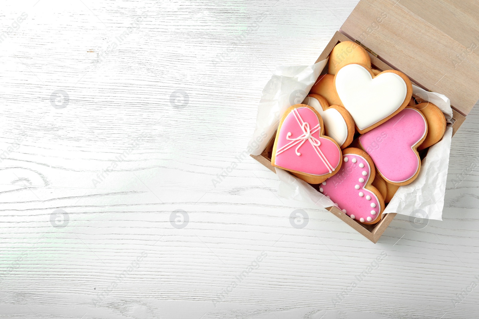 Photo of Decorated heart shaped cookies in wooden box and space for text on table, top view