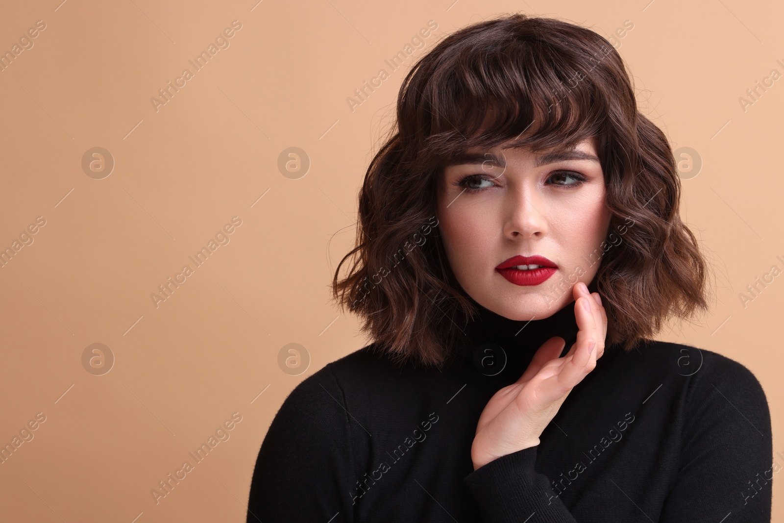 Photo of Portrait of beautiful young woman with wavy hairstyle on beige background. Space for text