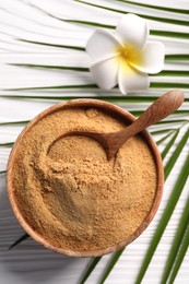 Photo of Coconut sugar and spoon in bowl on white wooden table, flat lay