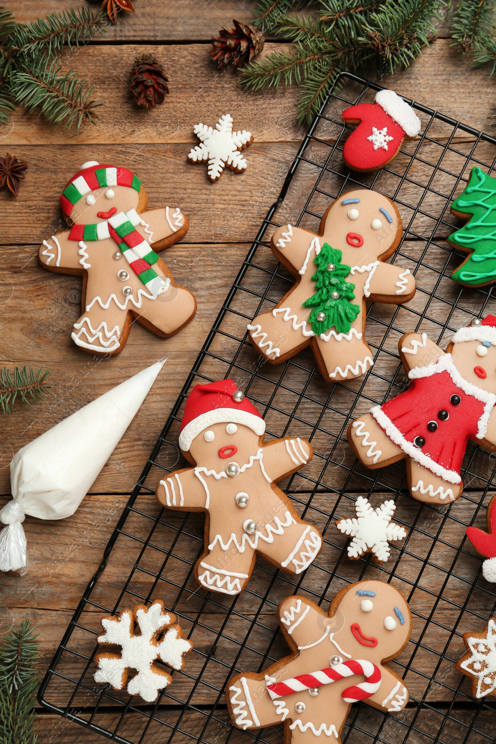 Photo of Delicious Christmas cookies and fir branches on wooden table, flat lay