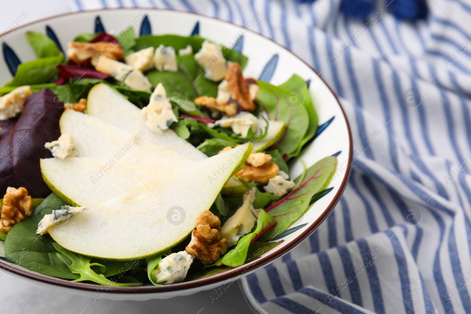 Photo of Delicious pear salad in bowl on table, closeup