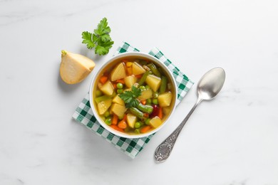 Photo of Bowl of delicious turnip soup served on white table, flat lay