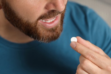 Closeup view of bearded man taking pill