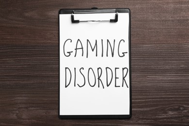 Clipboard with phrase Gaming Disorder on wooden table, top view