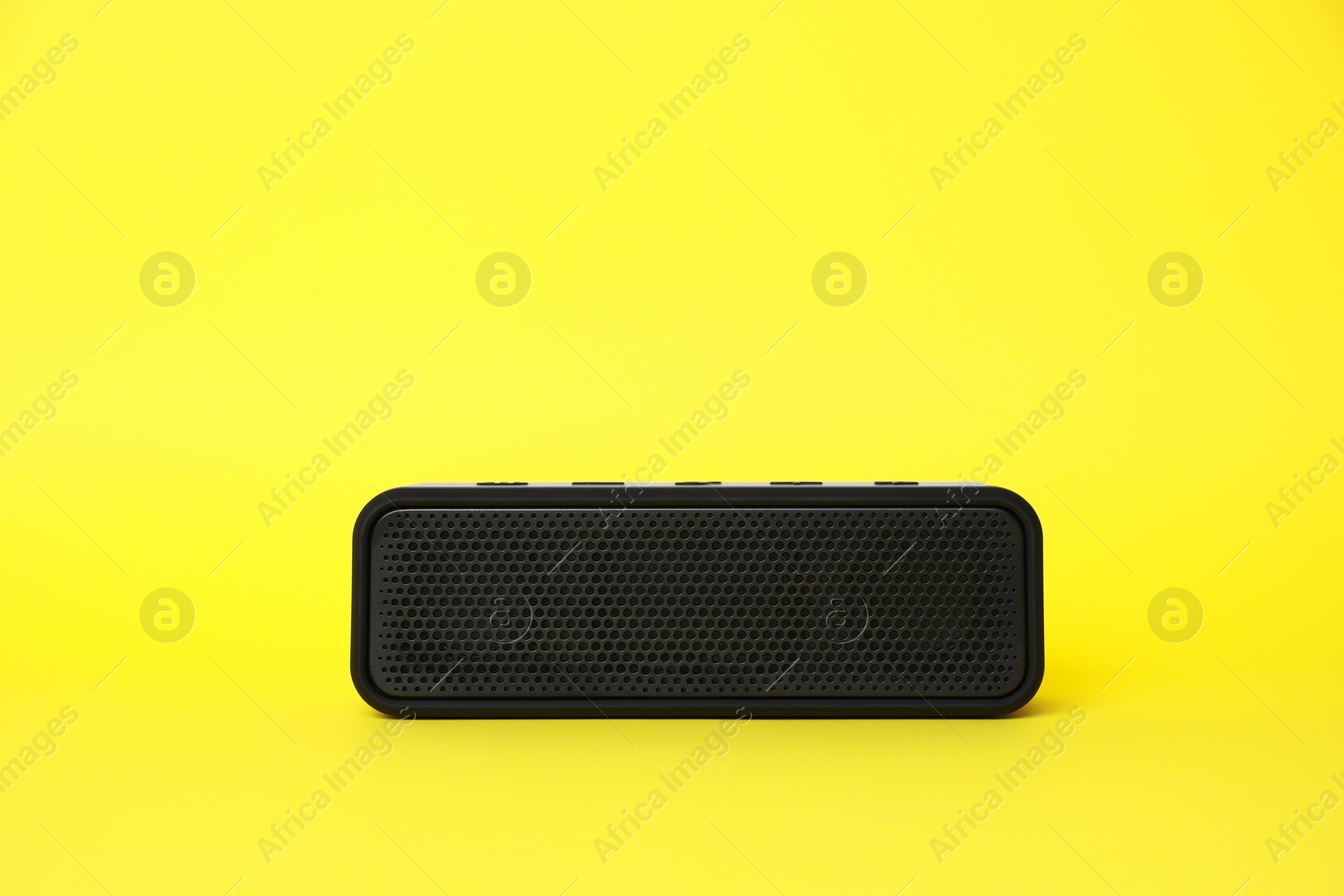 Photo of One portable bluetooth speaker on yellow background, space for text. Audio equipment