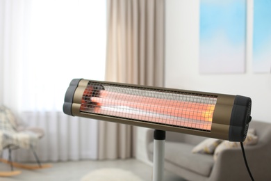 Photo of Modern electric infrared heater at home, closeup