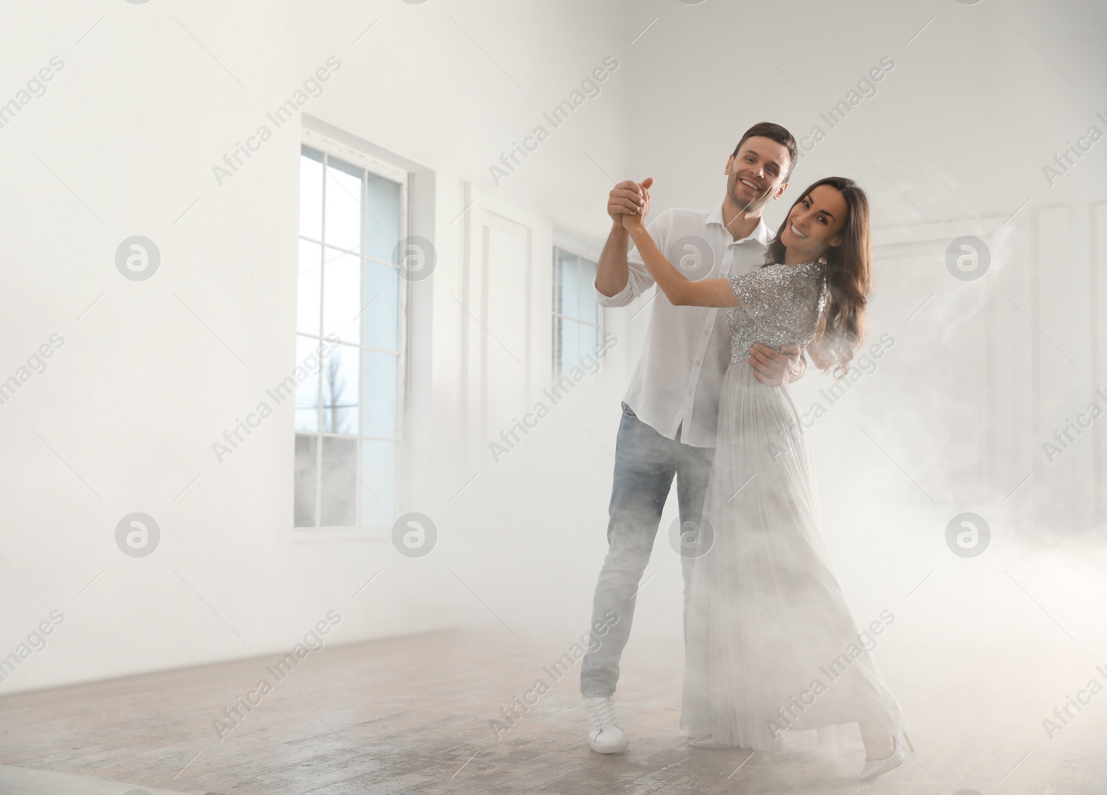 Photo of Lovely young couple dancing together in ballroom. Space for text