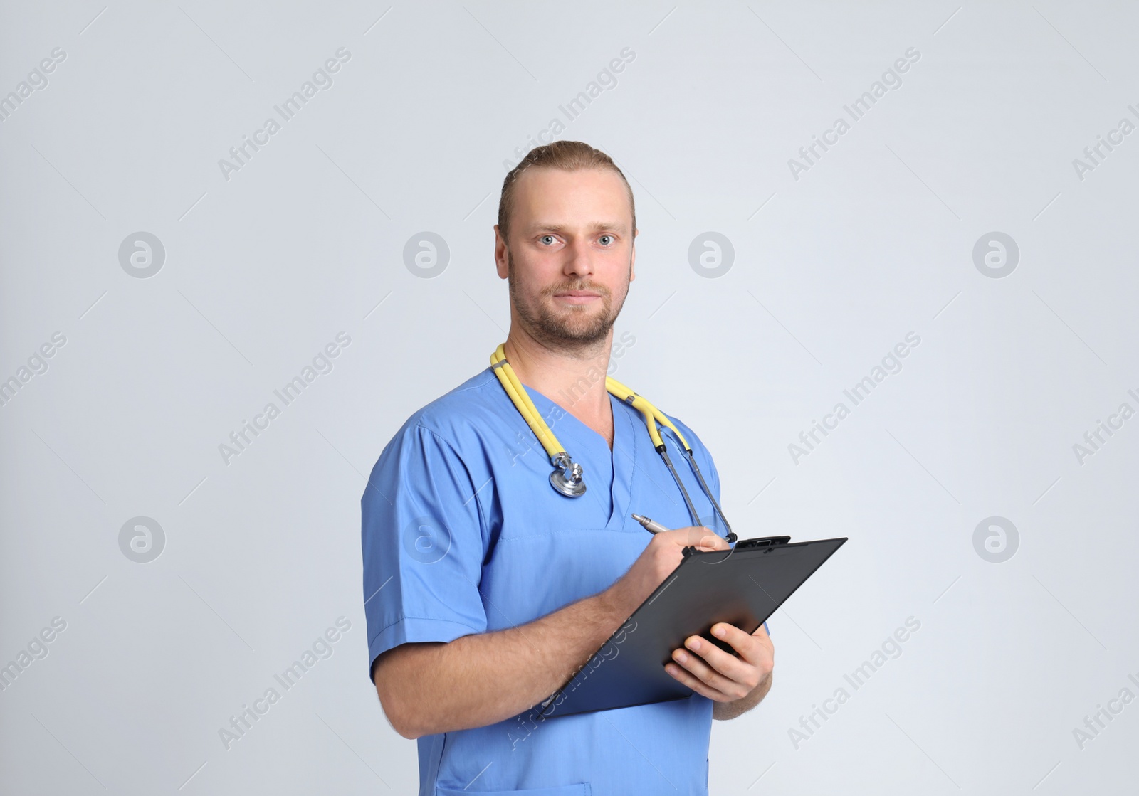 Photo of Portrait of medical assistant with stethoscope and clipboard on color background