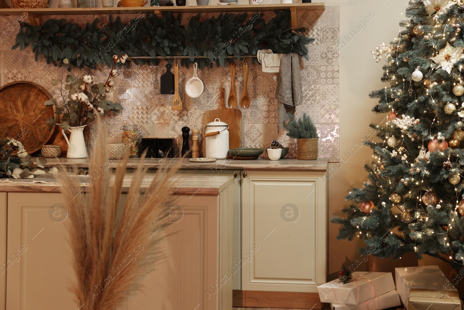 Photo of Stylish kitchen with festive decor and Christmas tree. Interior design