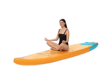 Happy woman practicing yoga on orange SUP board against white background