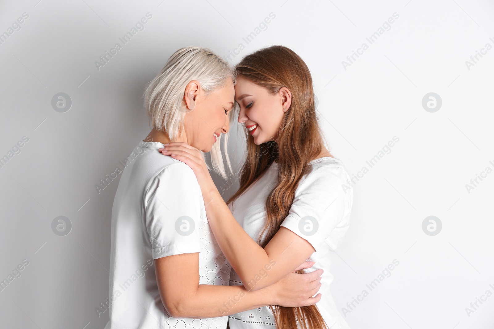 Photo of Mother and her adult daughter on white background