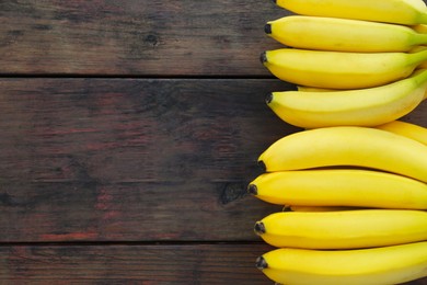 Ripe yellow bananas on wooden table, flat lay. Space for text