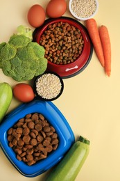 Photo of Dry pet food and products on beige background, flat lay