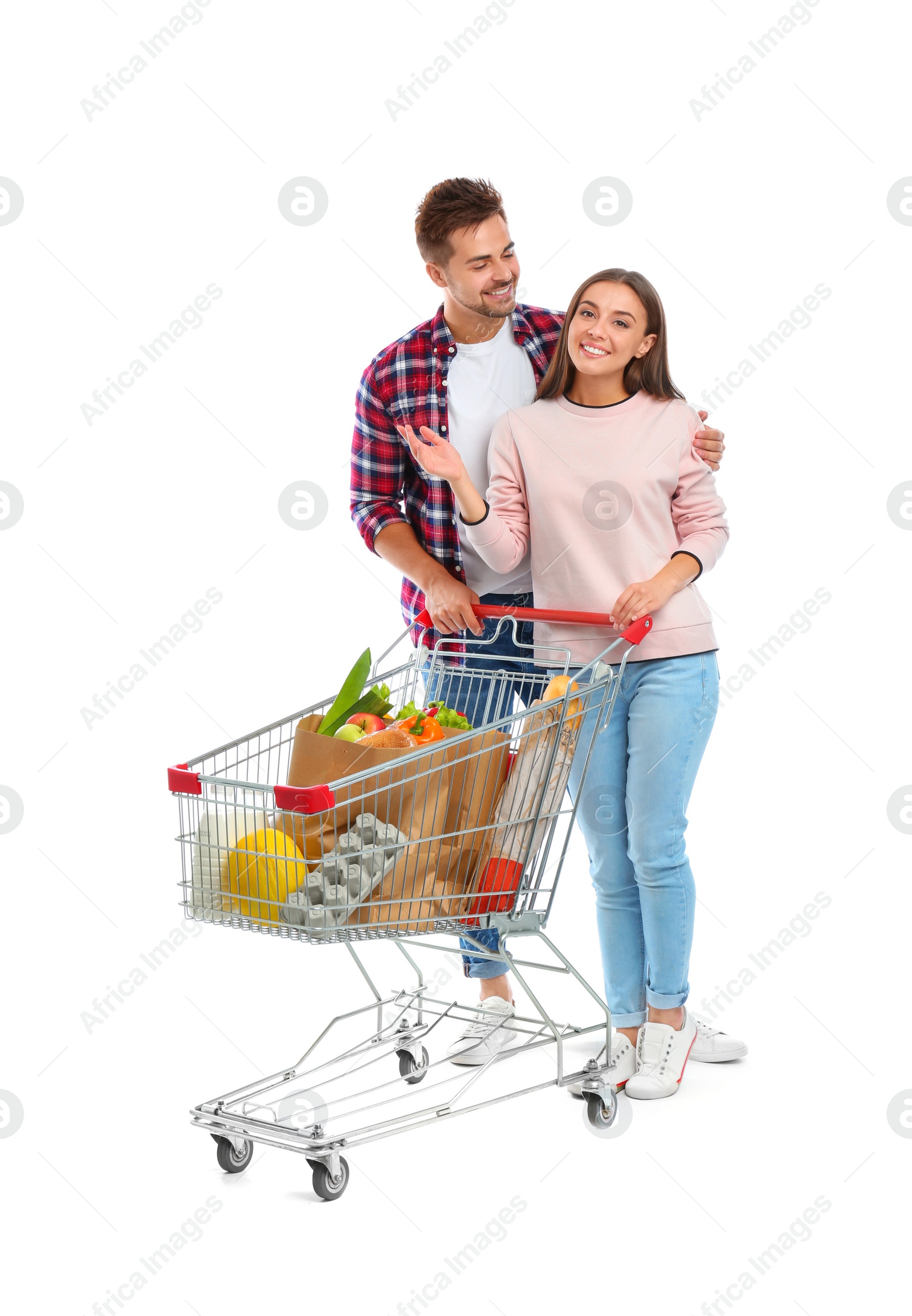 Photo of Young couple with full shopping cart on white background