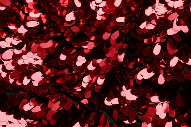Photo of Closeup view of red shiny sequin fabric as background