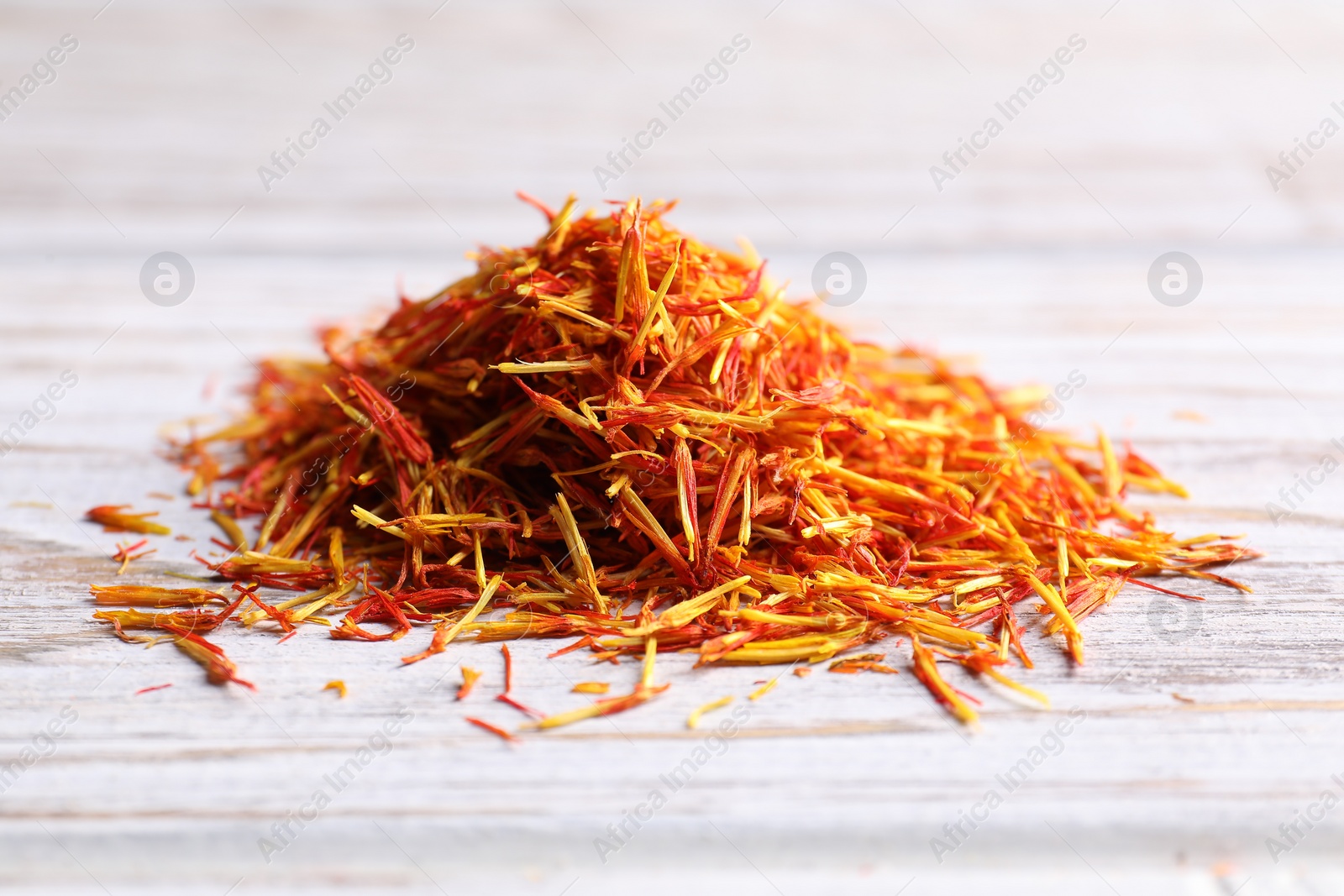 Photo of Aromatic saffron on wooden table, closeup view