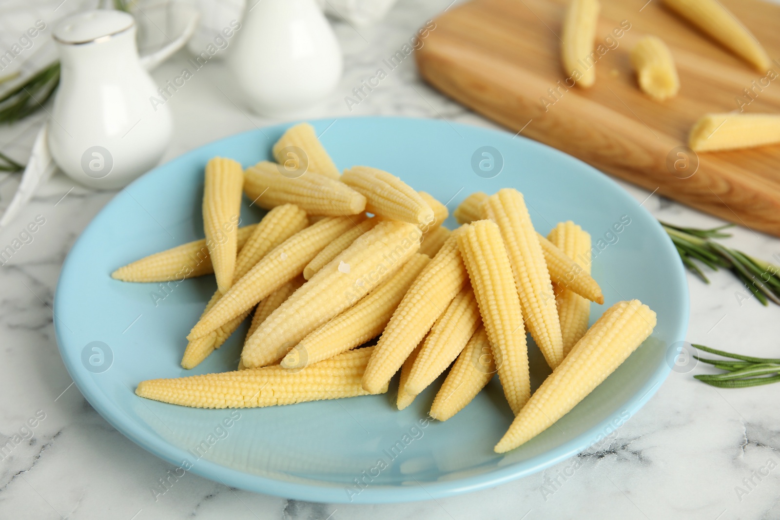 Photo of Fresh baby corn cobs on white marble table