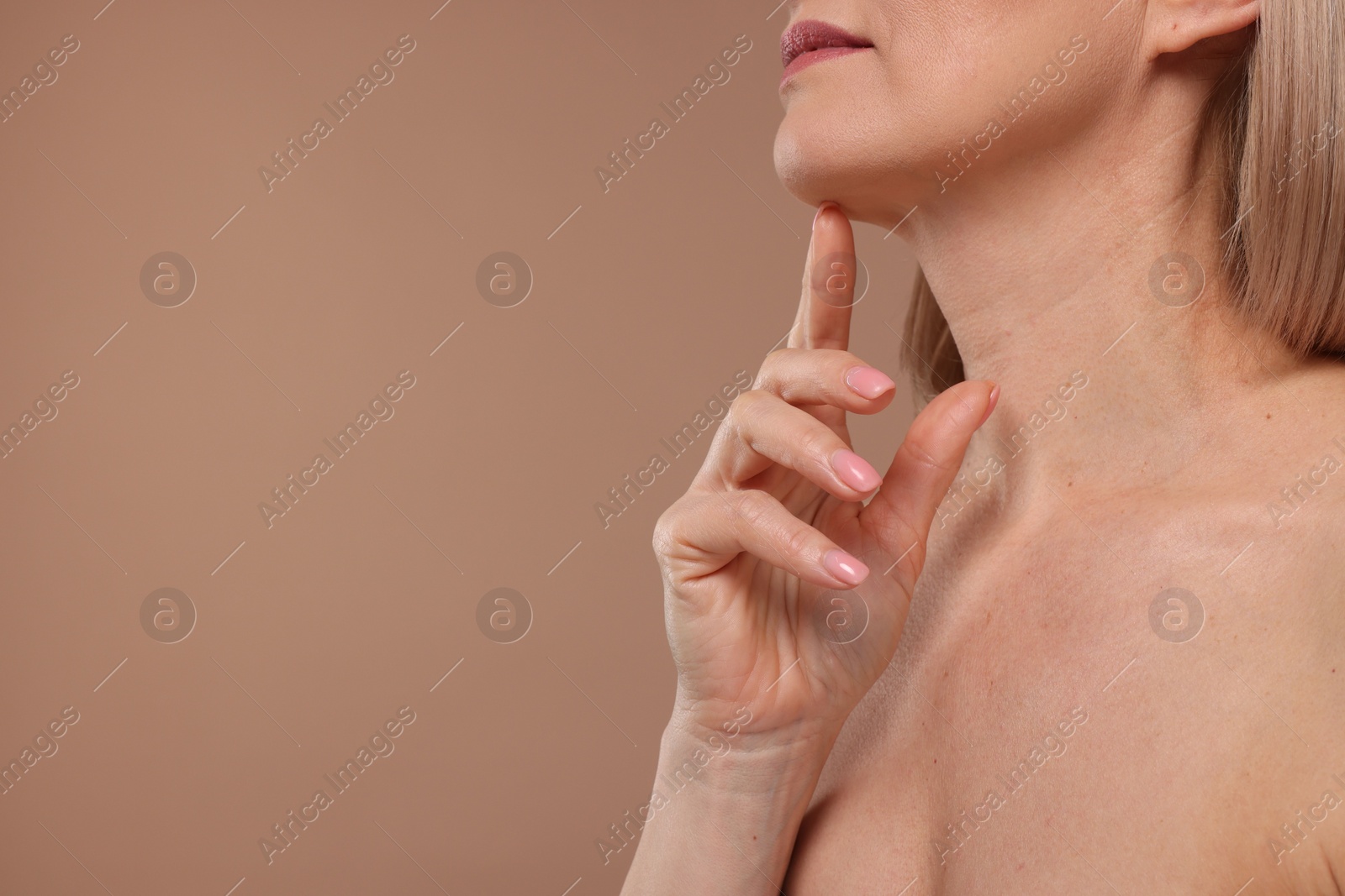 Photo of Woman touching her chin on beige background, closeup. Space for text