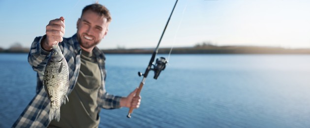 Image of Fisherman with fishing rod at riverside, space for text. Banner design