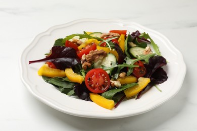 Photo of Tasty fresh vegetarian salad on white marble table, closeup