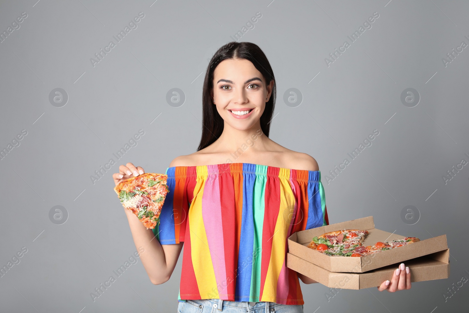 Photo of Beautiful woman with pizza on grey background