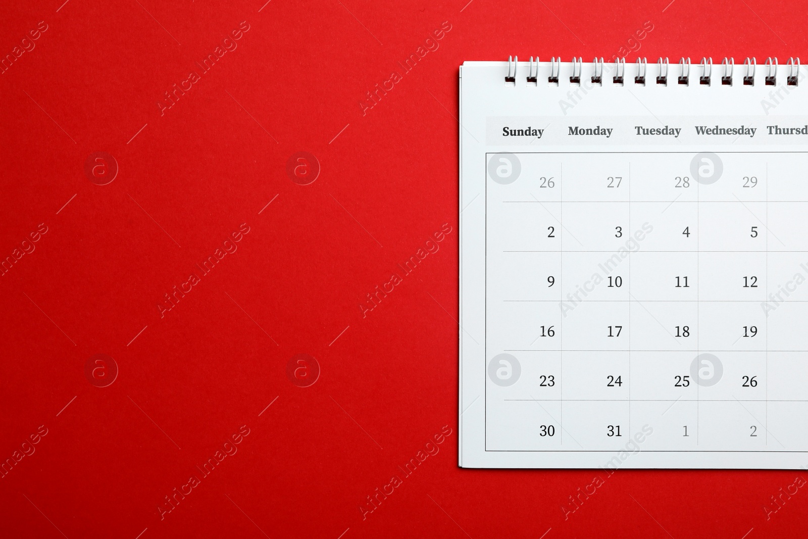 Photo of Paper calendar on red background, top view. Space for text