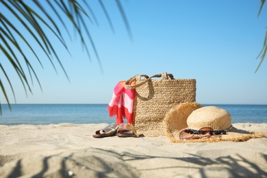 Photo of Stylish beach accessories on sandy sea shore