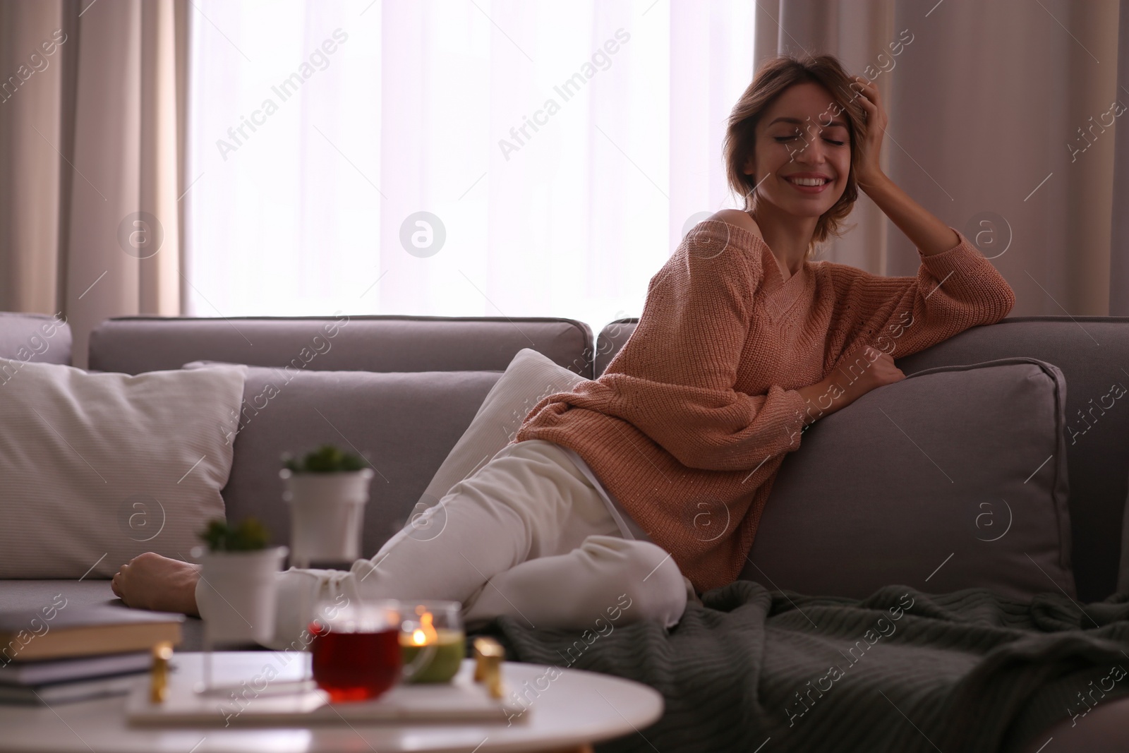 Photo of Beautiful young woman relaxing at home. Cozy atmosphere