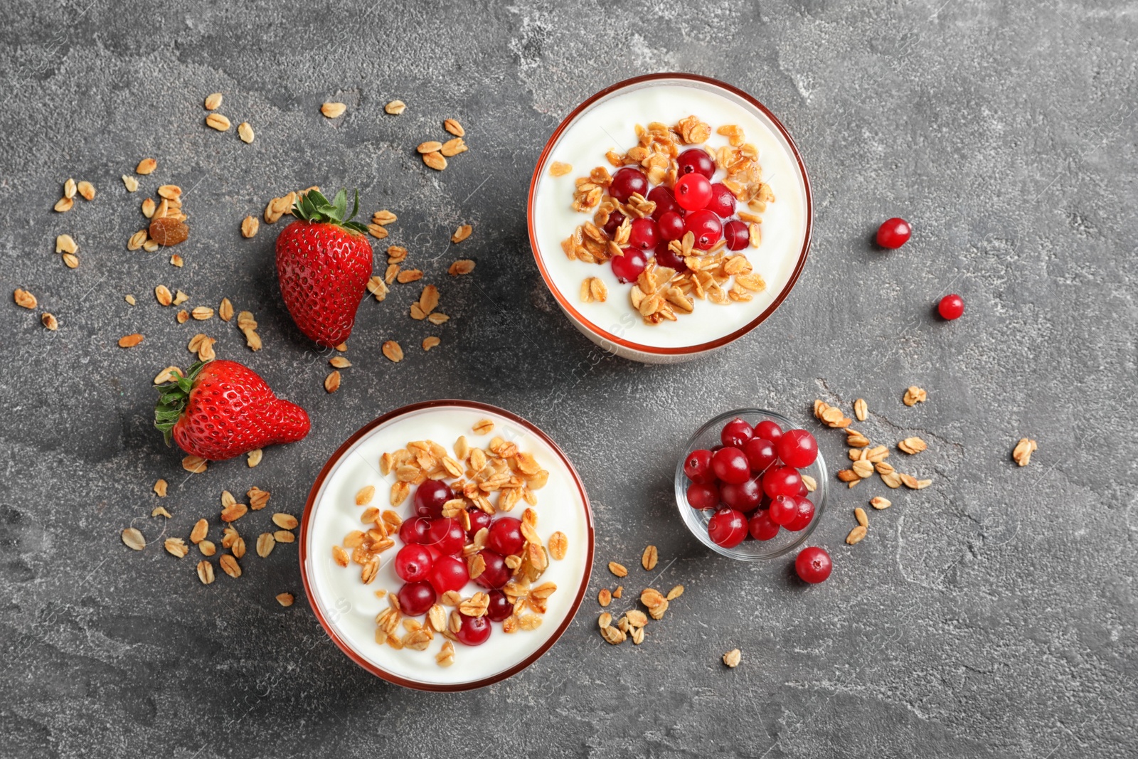 Photo of Glasses with yogurt, berries and granola on table, top view
