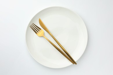 Photo of Plate, fork and knife on white background, top view