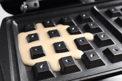 Modern Belgian waffle maker with dough, closeup