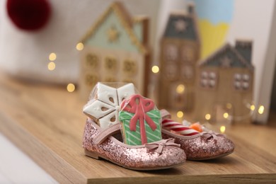 Photo of Sweets in pink ballet shoes on wooden table. Saint Nicholas Day tradition
