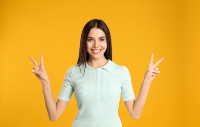Photo of Woman showing number four with her hands on yellow background