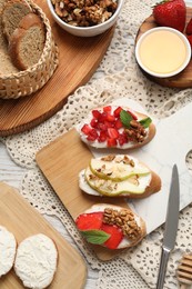 Board with different tasty ricotta bruschettas and ingredients on table, flat lay