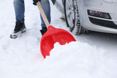 Man removing snow with shovel near car outdoors, closeup