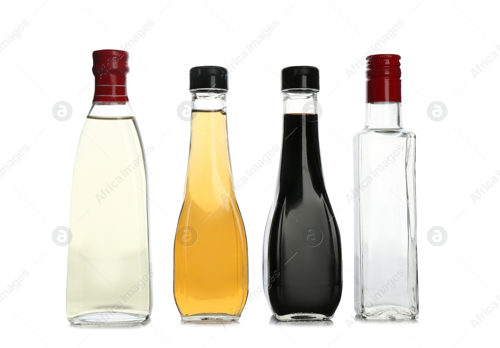 Photo of Glass bottles with different kinds of vinegar on white background