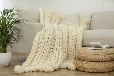 Photo of Knitted merino wool plaid on sofa in room