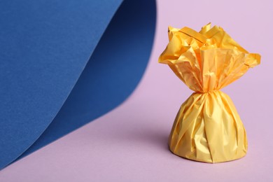 Photo of Candy in yellow wrapper on color background. Space for text