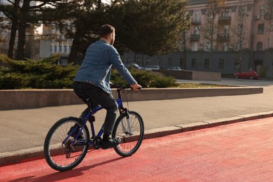 Man riding bicycle on lane in city