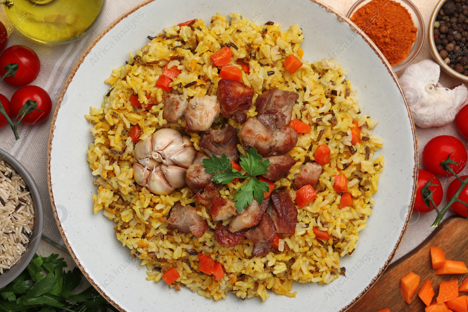 Photo of Delicious pilaf and products on table, flat lay