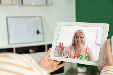 Woman having video chat with her grandmother at home, focus on screen