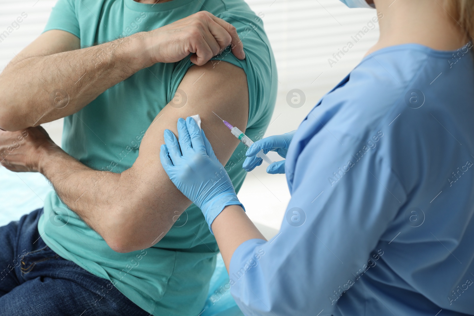 Photo of Doctor giving hepatitis vaccine to patient in clinic, closeup