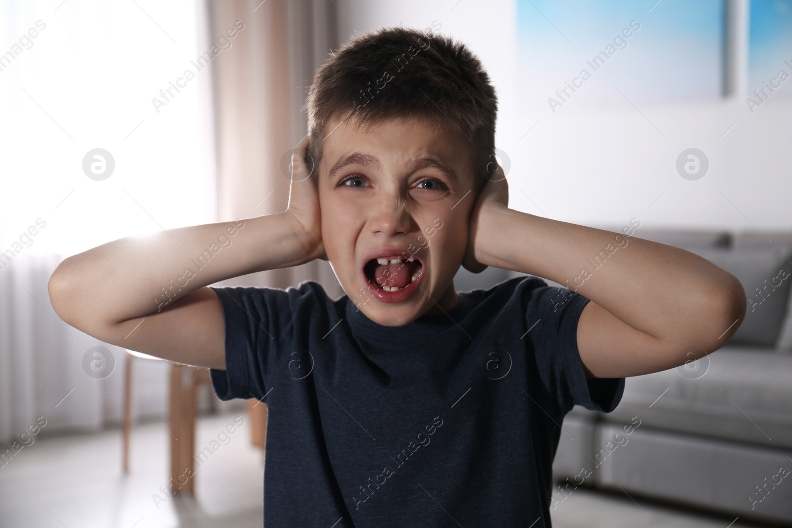 Photo of Scared little boy indoors. Domestic violence concept