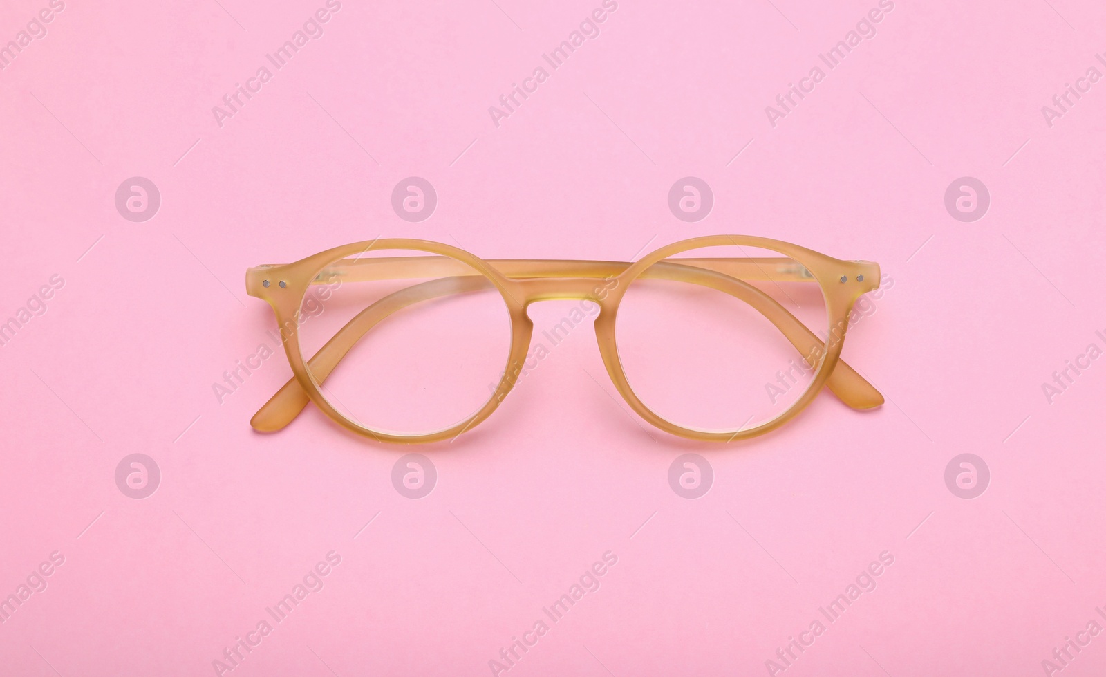 Photo of Glasses with corrective lenses on pink background, top view