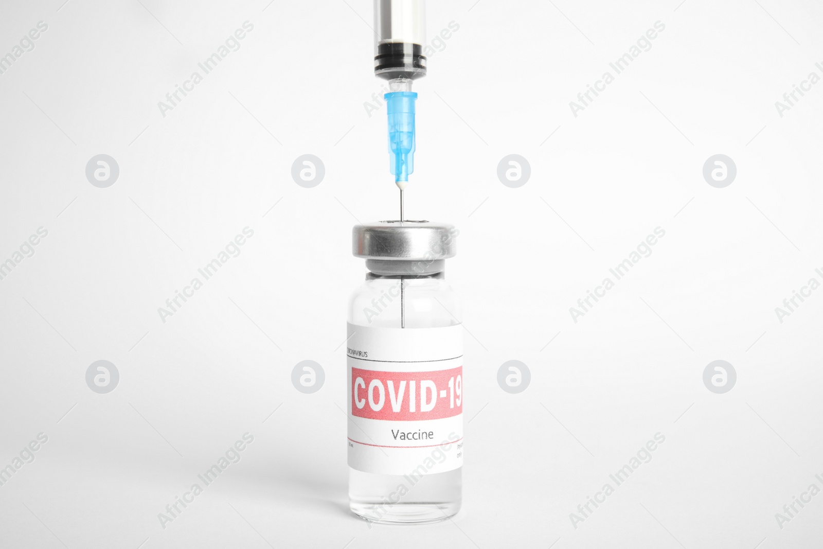 Photo of Filling syringe with coronavirus vaccine on white background