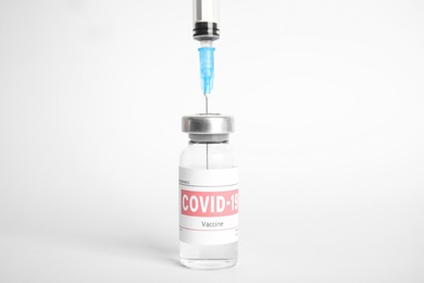 Filling syringe with coronavirus vaccine on white background