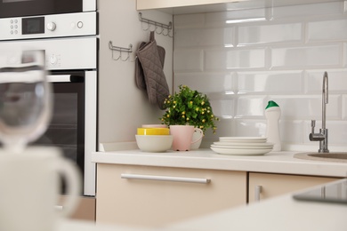 Photo of Set of clean dishes on table in kitchen