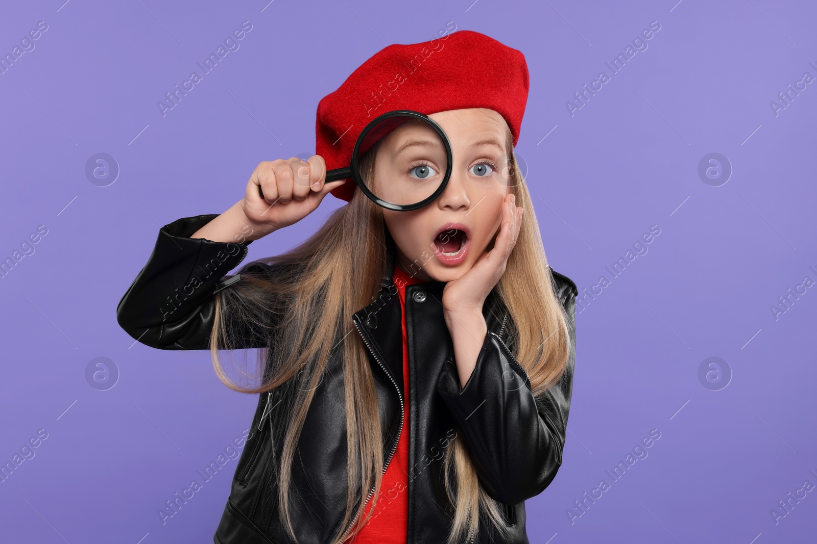 Photo of Cute little girl looking through magnifier on purple background